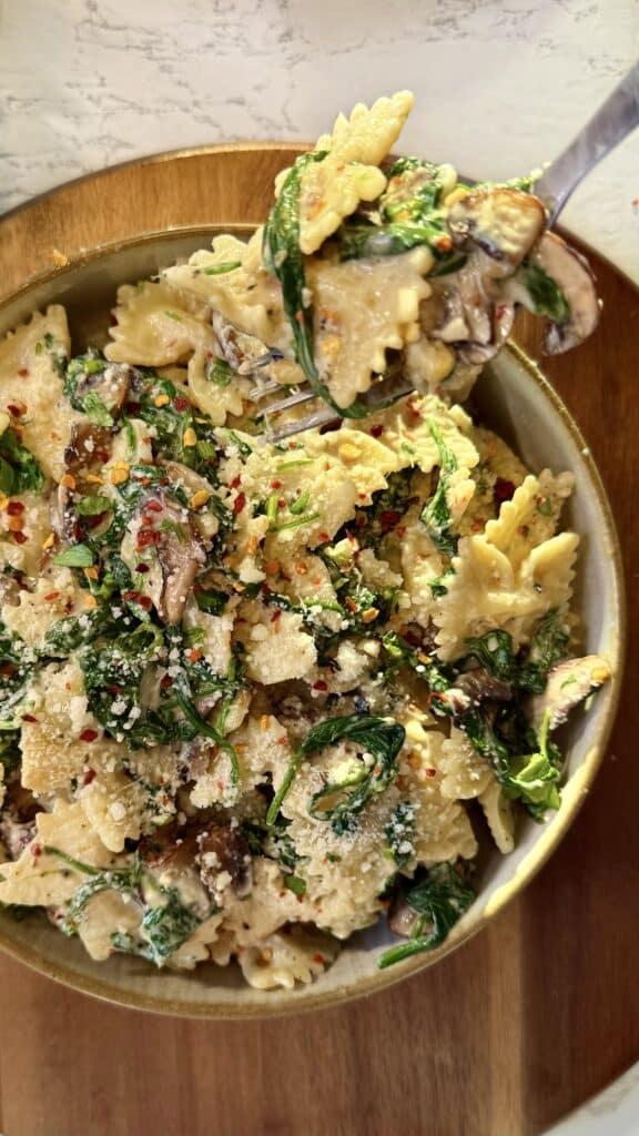 Tazón de pasta cremosa de espinacas y champiñones